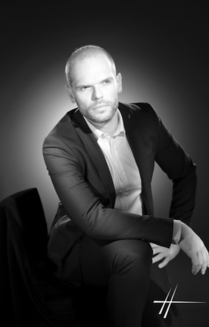 Patrick Pinot, portrait studio en noir et blanc, assis, veste et chemise